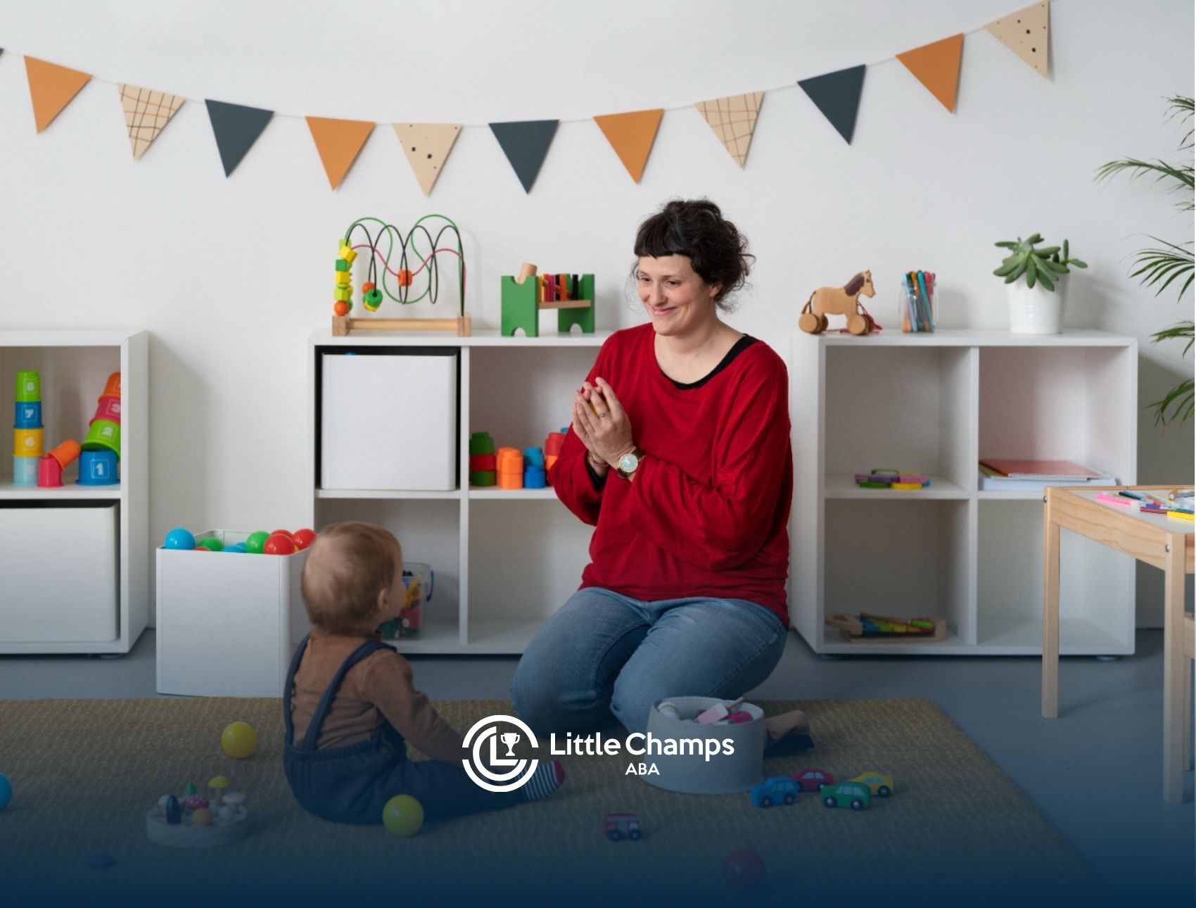 ABA therapist playing with a toddler on the floor.