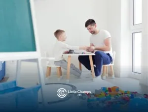 ABA therapist and autistic child playing together at a table.
