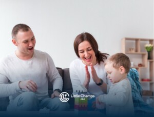 Autistic toddler building a block tower while parents clap in encouragement.