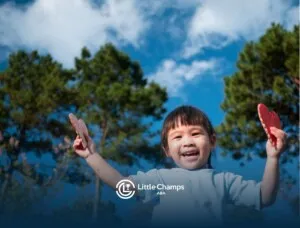 Autistic girl happily holding two heart-shaped objects outdoors.