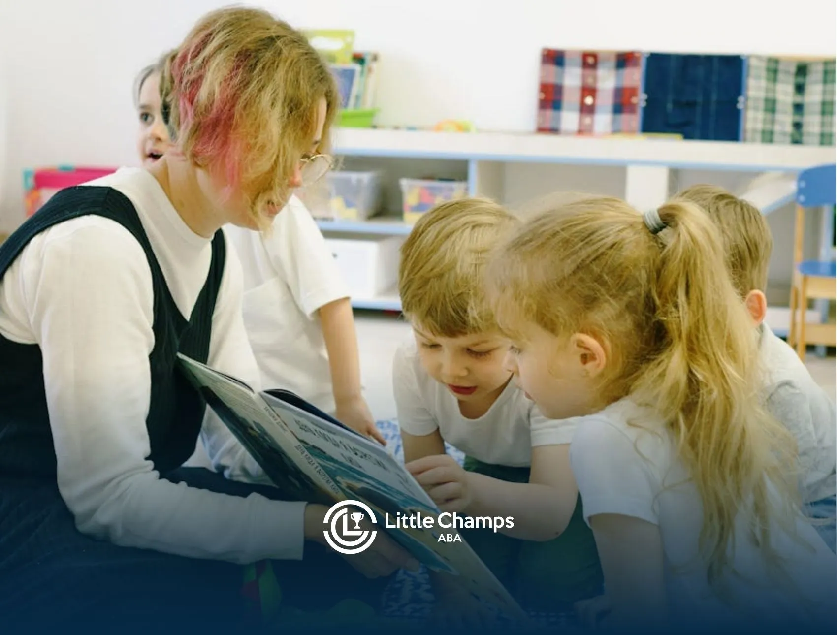 ABA therapist reading a book to autistic children sitting on the floor at a classroom in Utah.