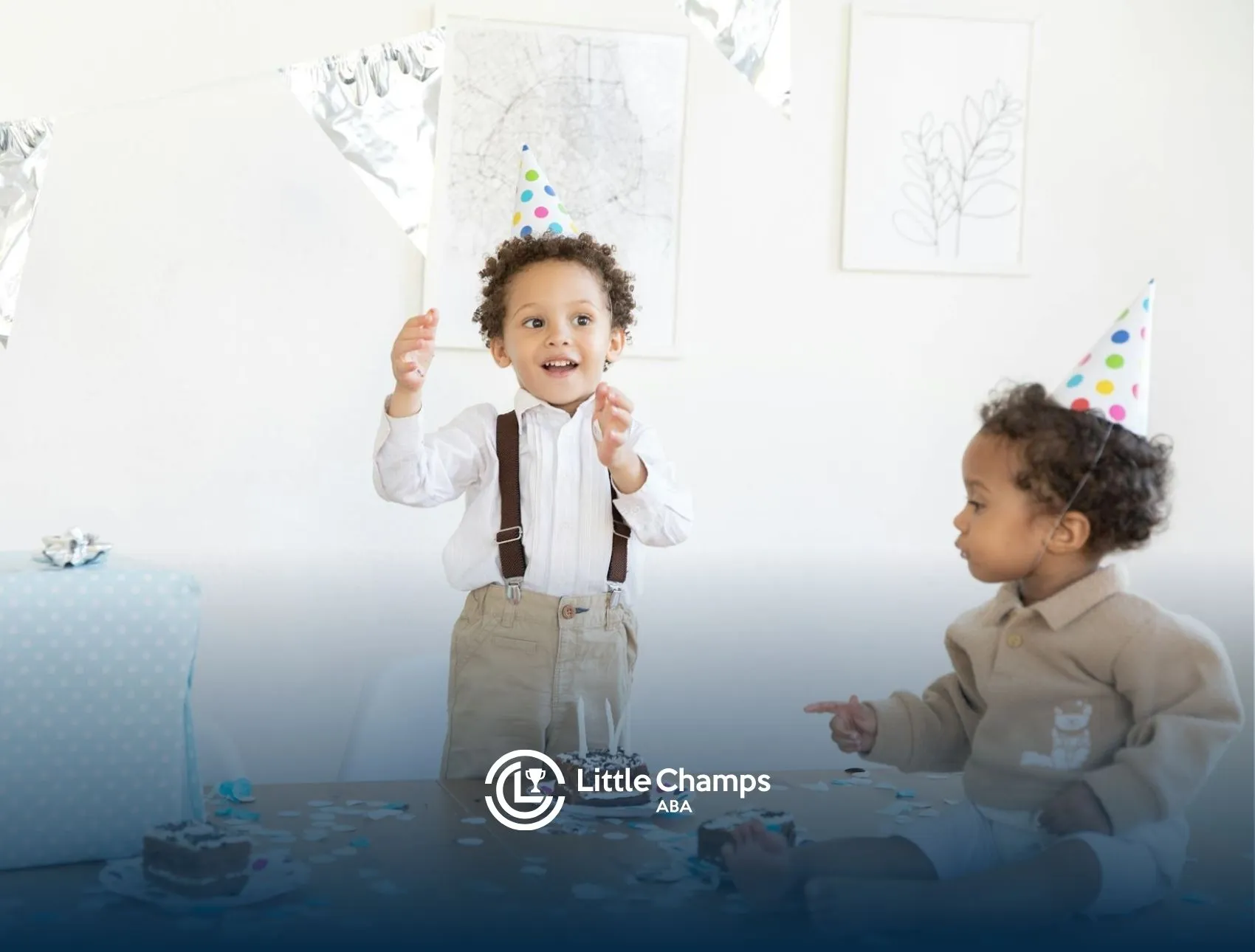 Two autistic children wearing party hats with cake and confetti at an autism awareness celebration.