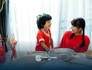 RBT and autistic boy in red clothes smiling at a table with dumplings and bamboo steamers in CO.