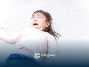 A little girl crying on the floor.