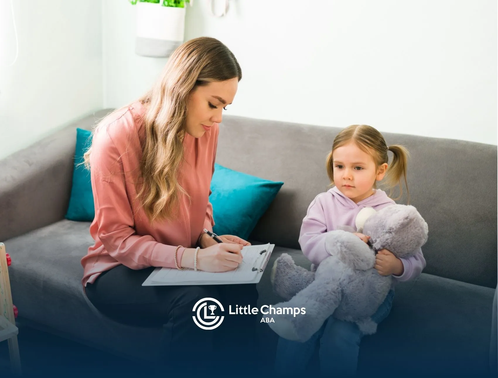 A therapist making notes in front of a little girl.