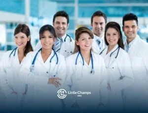 A group of eight smiling medical professionals in white lab coats with stethoscopes around their necks, exuding confidence and teamwork.
