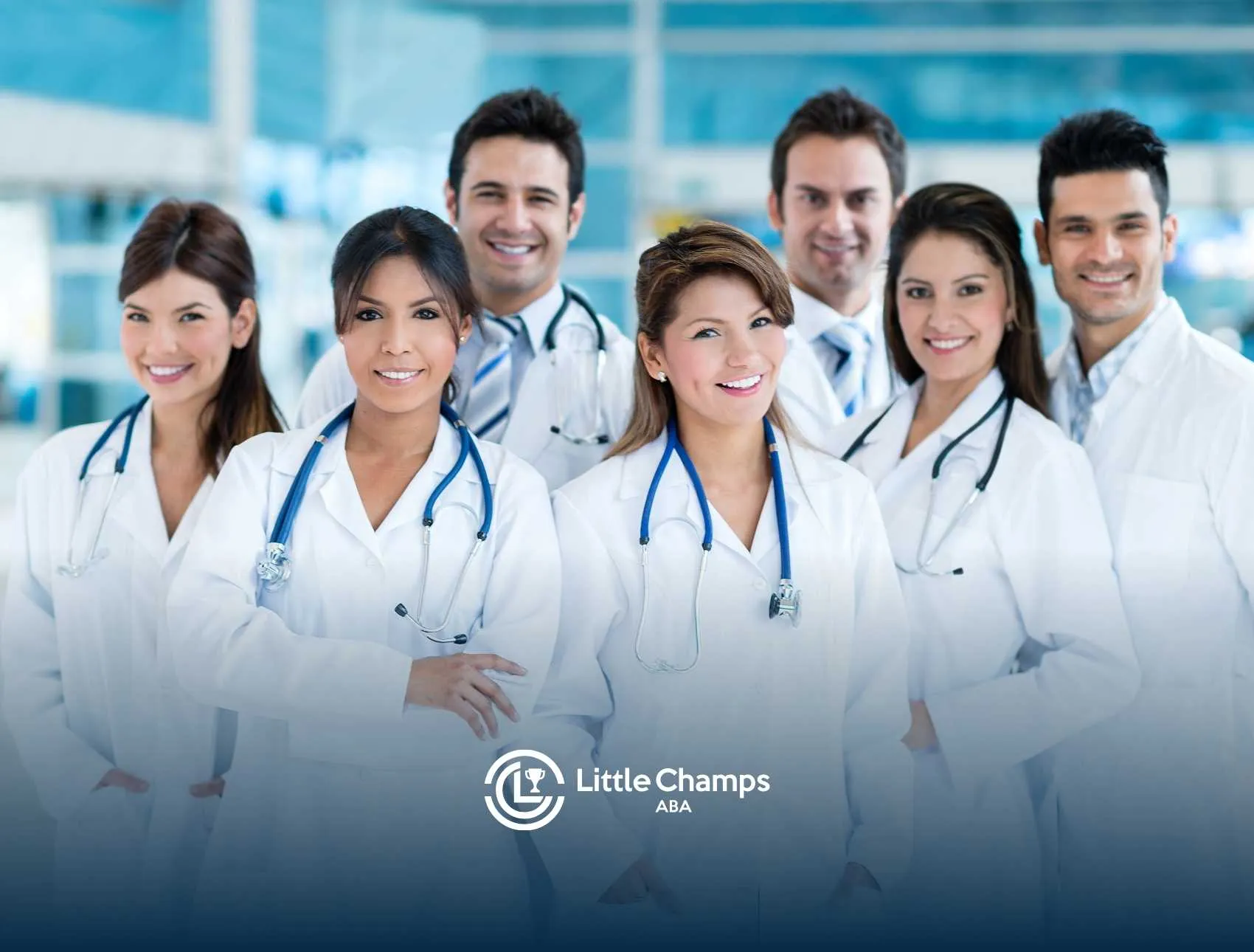 A group of eight smiling medical professionals in white lab coats with stethoscopes around their necks, exuding confidence and teamwork.