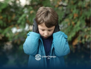 A young boy sits with his head in his hands, expressing frustration or sadness.