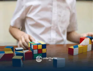 A child with autism is playing with Rubik's cubes on a table