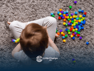 A child with autism is playing with colorful toys on the floor