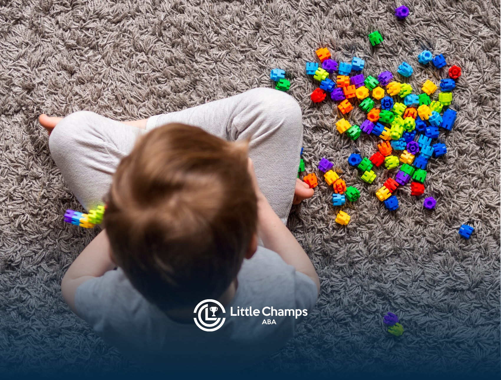 A child with autism is playing with colorful toys on the floor