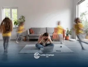 A mother is sitting in a living room holding her head while her daughter with autism is running around her