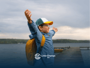 A child stands on a lakeside dock with arms outstretched