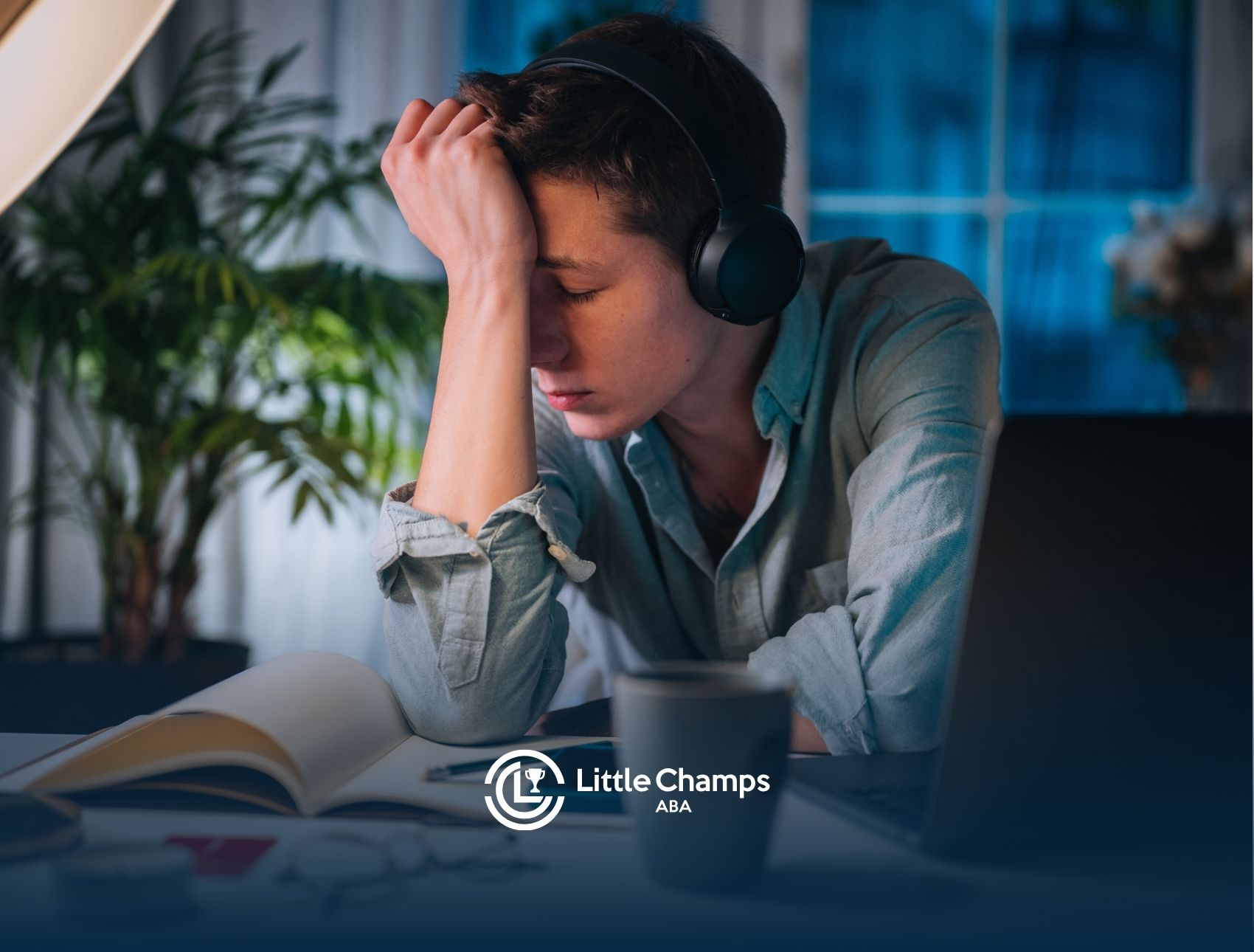 A boy wearing headphones looking frustrated, holding his forehead.