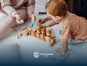 An autistic toddler playing with wooden educational toy numbers and shapes with adults nearby in UT.