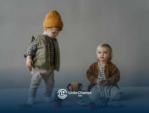 Two autistic toddlers sitting and standing near toy cars and puzzles on a gray floor in Colorado.