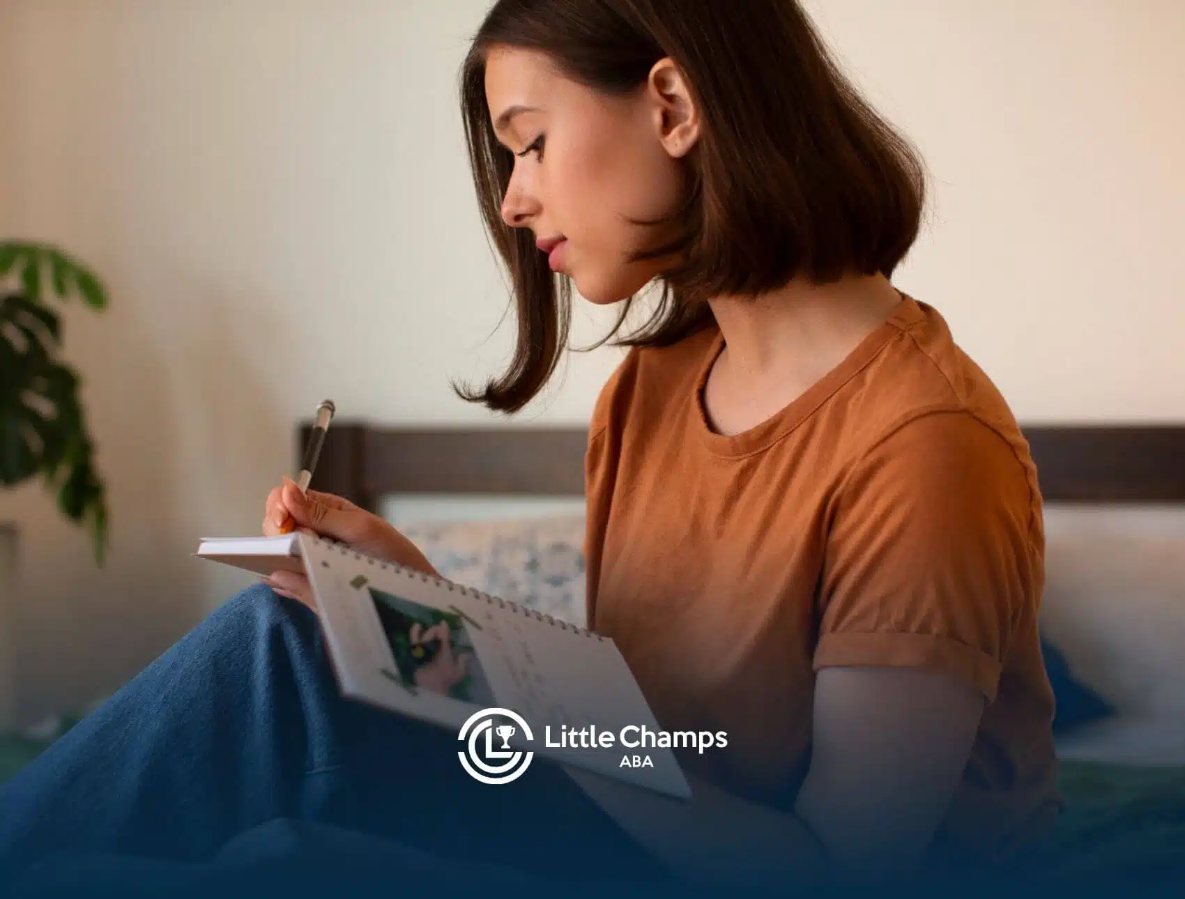 An autistic woman writing in a notebook while seated comfortably indoors.