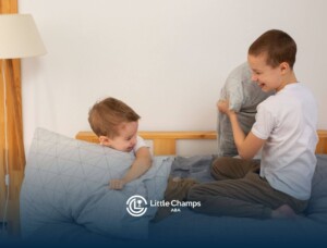 Two young kids playing with pillows, showing social interaction often encouraged in ABA therapy.