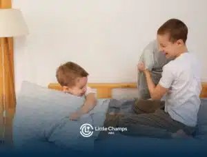 Two young kids playing with pillows, showing social interaction often encouraged in ABA therapy.
