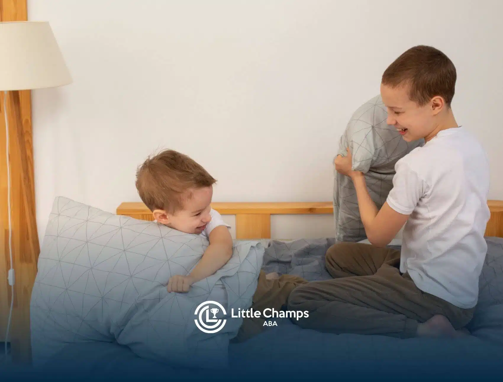 Two young kids playing with pillows, showing social interaction often encouraged in ABA therapy.