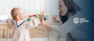 ABA therapist and toddler high-fiving during structured play in ABA therapy.