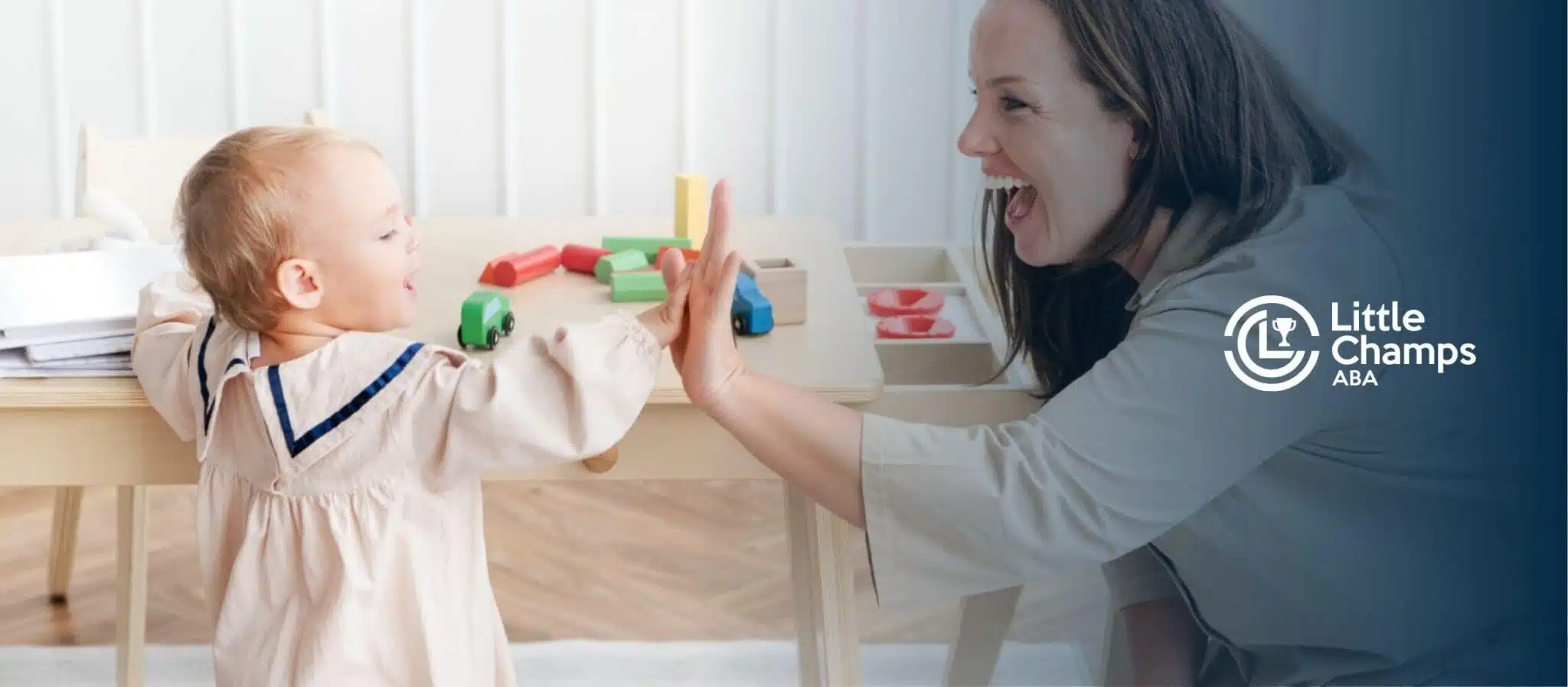 ABA therapist and toddler high-fiving during structured play in ABA therapy.
