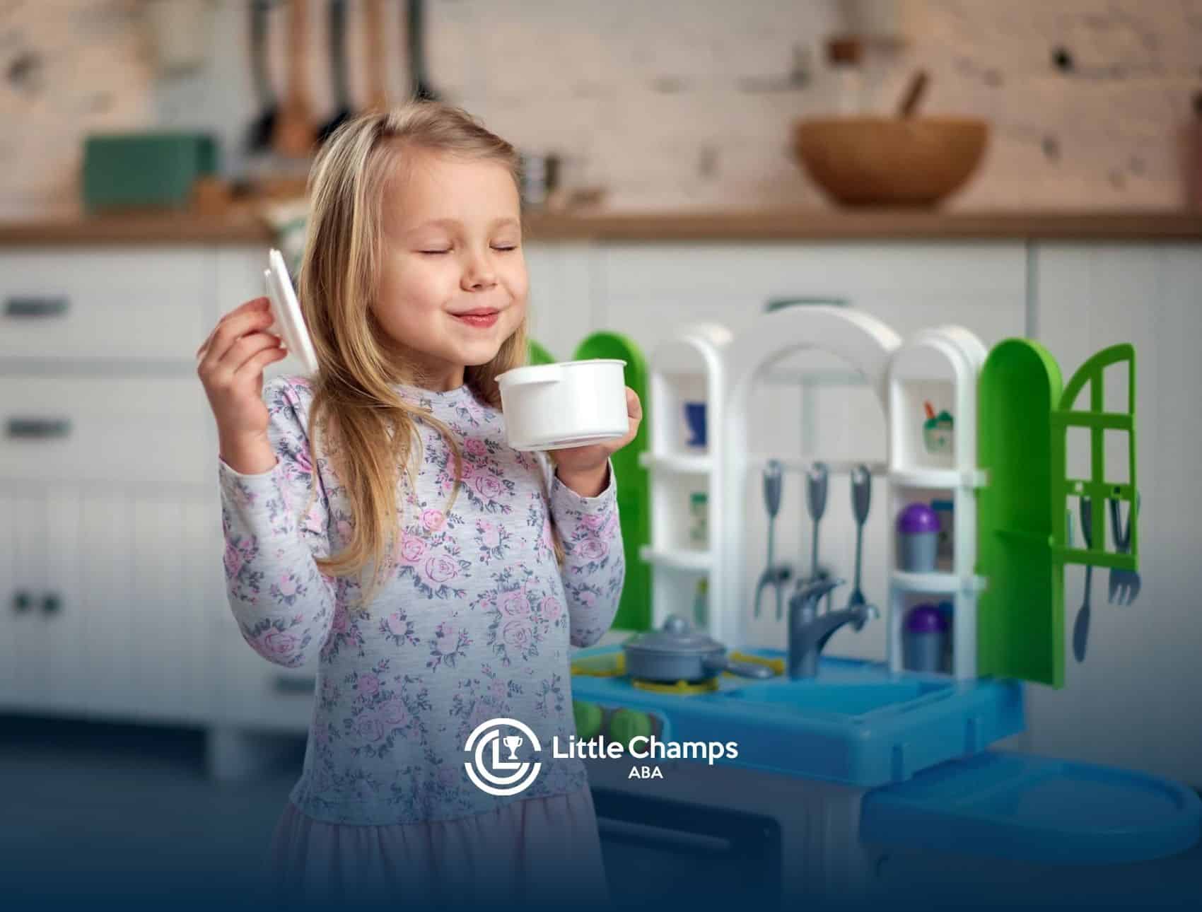 Smiling young autistic girl holding a cup while playing with a kitchen set during ABA therapy in UT.