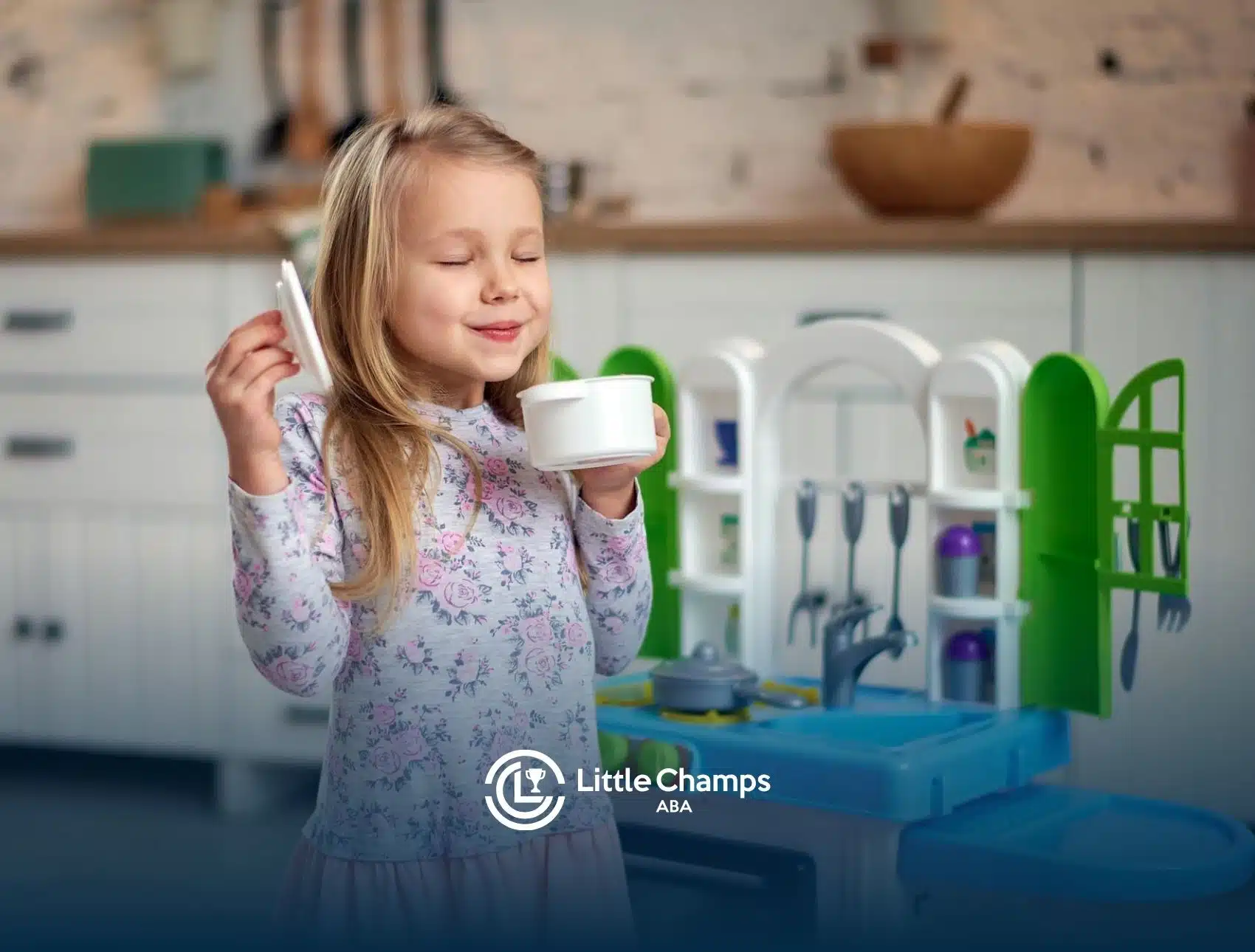 Smiling young autistic girl holding a cup while playing with a kitchen set during ABA therapy in UT.