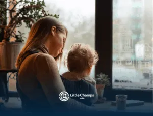 A mother and her child with autism sitting at a table by the window
