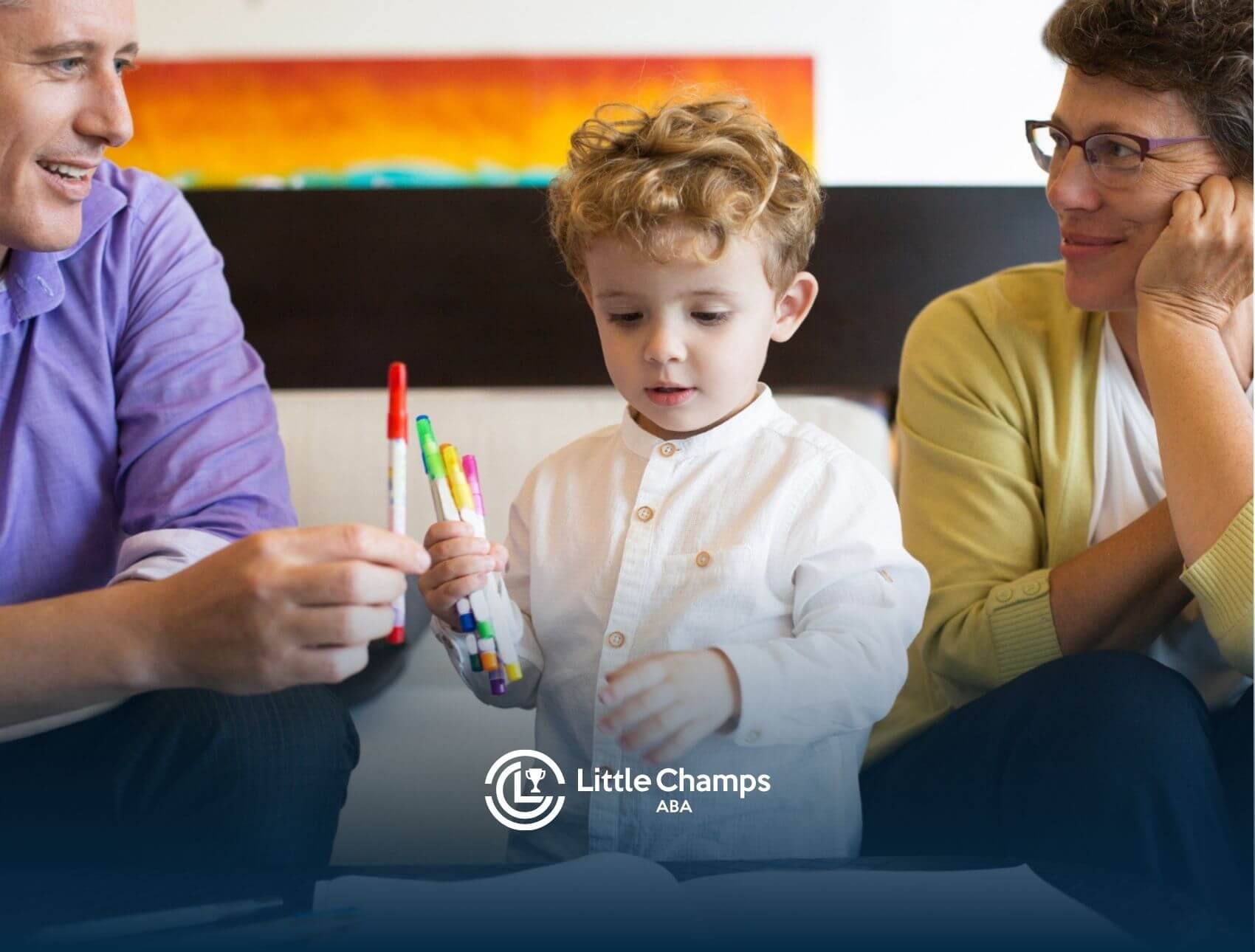 Father, mother, and son with markers and paper in ABA therapy parent training.