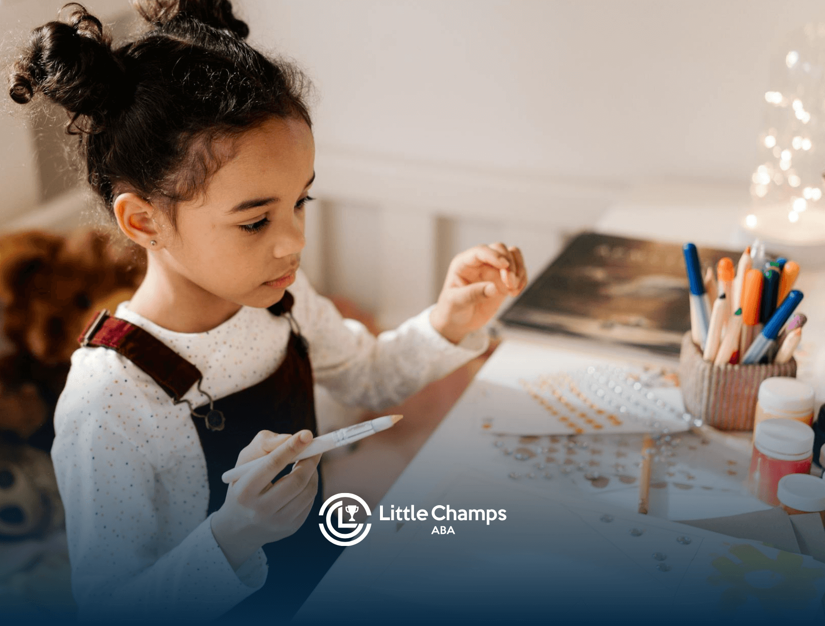A young girl focused on crafting with pens, stickers, and colored paper at a table during in-home ABA therapy in UT.