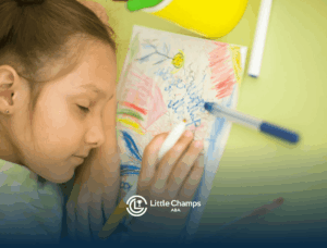 Young girl resting with eyes closed on top of her colorful drawing in ABA therapy.