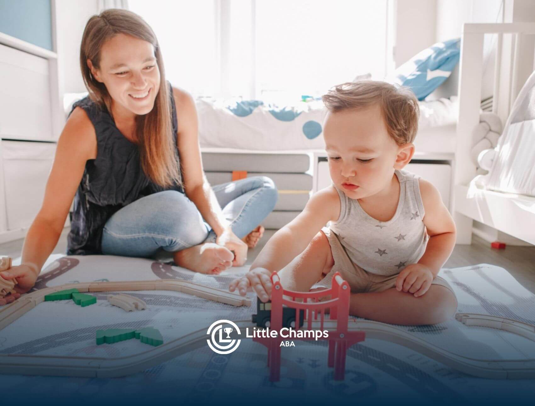 ABA therapist playing with toddler using wooden toy train set in ABA therapy.