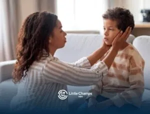 An ABA therapist comforting a boy with autism while sitting on couch in ABA therapy.