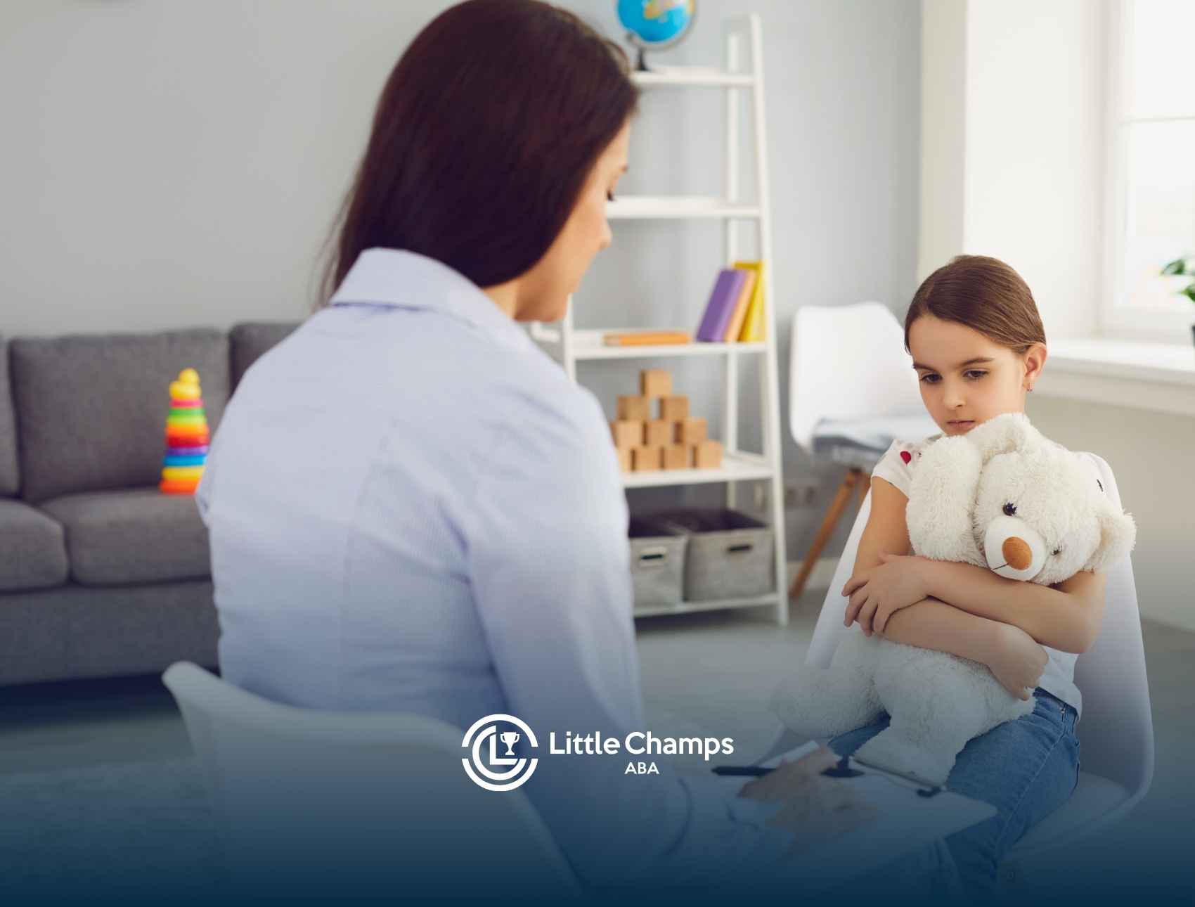 A therapist talks to a young girl clutching a teddy bear in a cozy room with toys and books. The mood is calm and supportive.