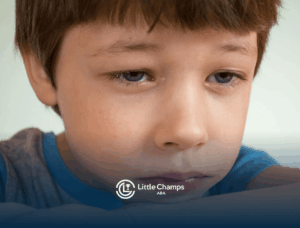 Sad autistic boy resting his head on his arm with tears in his eyes as he experience autism meltdown in CO.