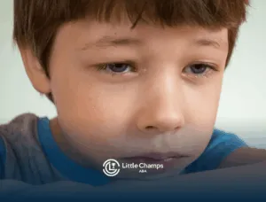 Sad autistic boy resting his head on his arm with tears in his eyes as he experience autism meltdown in CO.