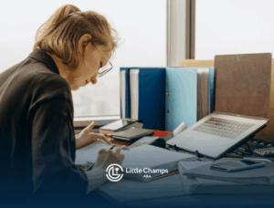 An RBT student studying hard for her upcoming RBT exam at desk filled with laptop and binders in Colorado.