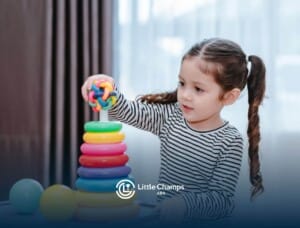 Young girl with autism stacking colorful toy rings.
