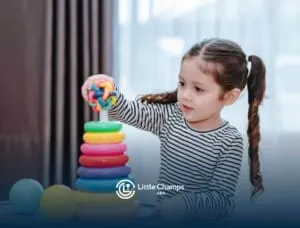 Young girl with autism stacking colorful toy rings.