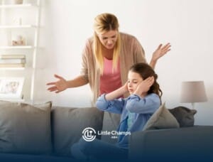 A girl with autism covering ears while a BCBA talks to her.