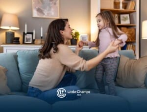 BCBA holding hands with child on couch in ABA therapy.