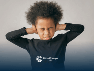 An autistic child covering ears tightly with eyes closed in discomfort during in-home ABA therapy session in UT.