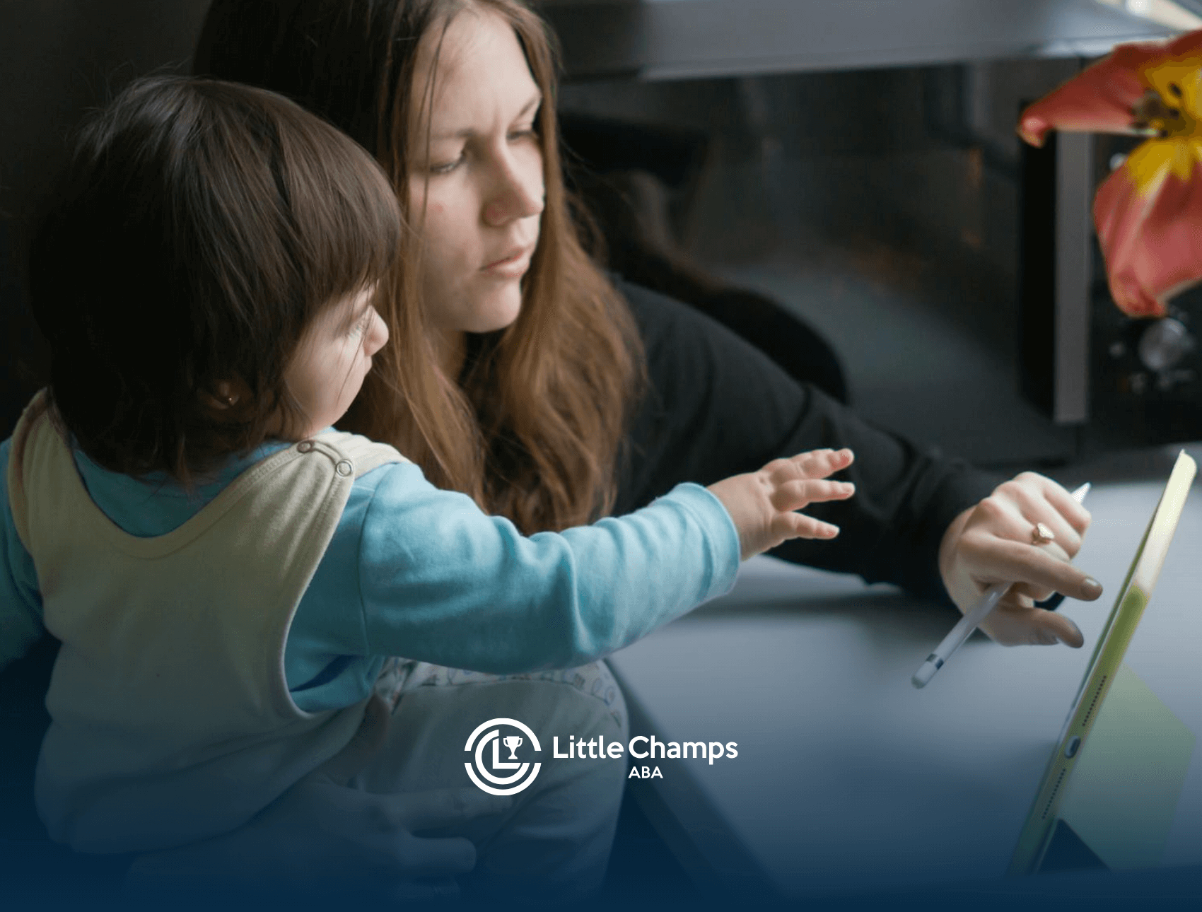 An ABA therapist teaching an autistic toddler with an AAC device during daycare ABA therapy in Colorado.