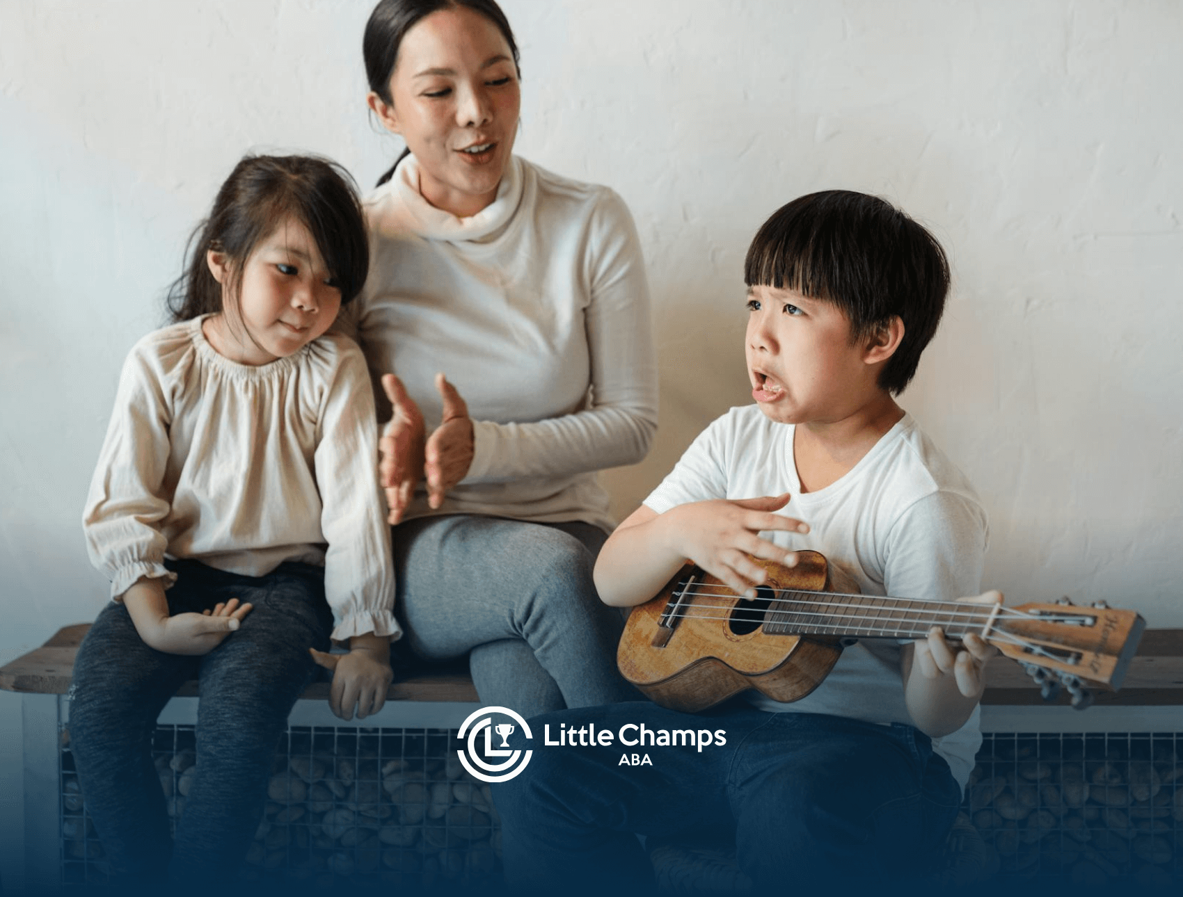 An ABA therapist and autistic children playing ukulele together during in-home ABA therapy session in Colorado.