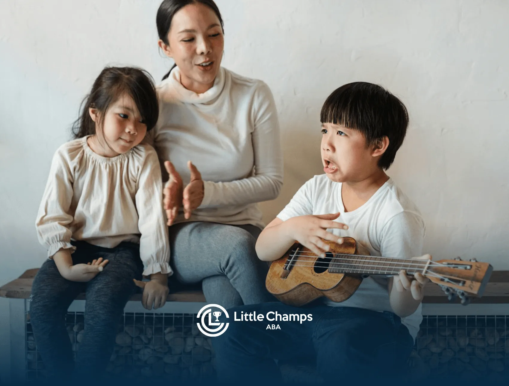 An ABA therapist and autistic children playing ukulele together during in-home ABA therapy session in Colorado.