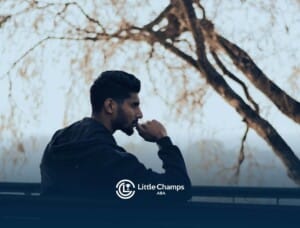 Autistic man sitting on a bench outdoors looking thoughtful under a tree and thinking for something in Colorado.