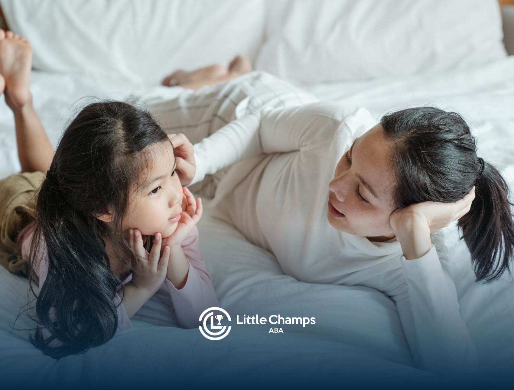 ABA therapist and & autistic girl lying on a bed, talking & smiling together After therapy Session.