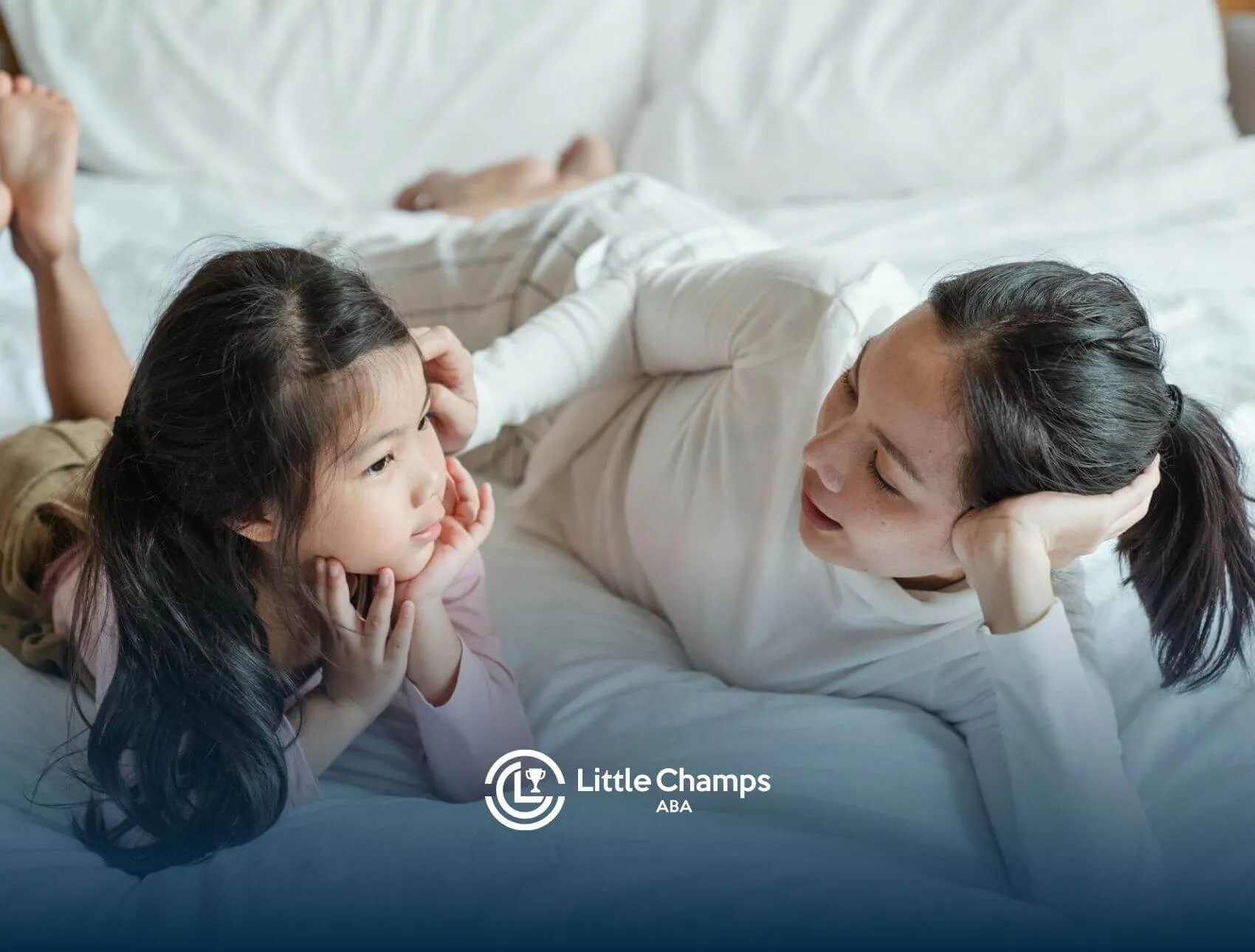 ABA therapist and & autistic girl lying on a bed, talking & smiling together After therapy Session.