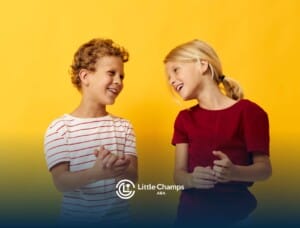 Two children with autism laughing together against yellow background.